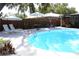 Backyard with a pool, lounge chairs, a table, privacy fence and shade umbrella at 1540 Lime St, Clearwater, FL 33756