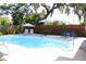 A lovely backyard has a pool with lounge chairs, a shade umbrella, and a privacy fence at 1540 Lime St, Clearwater, FL 33756