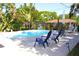 Inviting backyard pool area with lounge chairs and lush tropical landscaping, perfect for relaxation and entertaining at 1540 Lime St, Clearwater, FL 33756