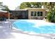 Backyard pool area with mature landscaping, patio area, and an enclosed porch for indoor-outdoor living at 1540 Lime St, Clearwater, FL 33756