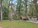 Secluded backyard area featuring a patio set and a scenic view of the surrounding forest at 18255 Lake Lindsey Rd, Brooksville, FL 34601