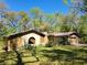 A cozy single-Gathering home featuring a rustic stone facade and lush greenery, creating a private feel at 18255 Lake Lindsey Rd, Brooksville, FL 34601