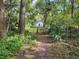 Quaint white home surrounded by lush greenery and trees, nestled in a natural setting at 18255 Lake Lindsey Rd, Brooksville, FL 34601