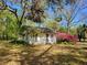 Charming white cottage with a lovely garden and mature trees in a serene, natural setting at 18255 Lake Lindsey Rd, Brooksville, FL 34601