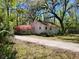 Charming home exterior with blooming pink flowers and gravel driveway at 18255 Lake Lindsey Rd, Brooksville, FL 34601