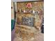 Stone fireplace with a wooden mantel displaying decorations and artwork at 18255 Lake Lindsey Rd, Brooksville, FL 34601
