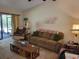 Cozy living room featuring a comfortable sofa, recliner, and sliding glass doors at 18255 Lake Lindsey Rd, Brooksville, FL 34601
