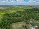 Surrounding landscape of home from an aerial view with mature trees and pasture surrounding area at 18308 Valor Path, Brooksville, FL 34604