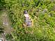 Overhead aerial view of the property with mature trees surrounding the home with an in ground pool at 18308 Valor Path, Brooksville, FL 34604