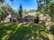 Spacious backyard with mature trees and a screened-in porch area at 18308 Valor Path, Brooksville, FL 34604