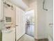 Bathroom with a white pedestal sink, tile flooring, and an open door to another room at 18308 Valor Path, Brooksville, FL 34604