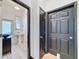 Bright bathroom with black door and pedestal sink; features a tiled floor at 18308 Valor Path, Brooksville, FL 34604