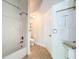 Cozy bathroom featuring a shower-tub combo and neutral-toned tile flooring at 18308 Valor Path, Brooksville, FL 34604