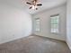 A simple bedroom with two windows for natural light and neutral carpet at 18308 Valor Path, Brooksville, FL 34604