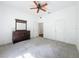 Spacious bedroom with neutral carpet, ceiling fan, and dark wood dresser at 18308 Valor Path, Brooksville, FL 34604