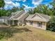 Backyard home view shows well maintained lawn, exterior home matching shutters and siding, and a bright partly cloudy sky at 18308 Valor Path, Brooksville, FL 34604