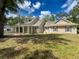Charming home featuring a spacious front yard, inviting porch, and classic architectural details under a partly cloudy sky at 18308 Valor Path, Brooksville, FL 34604