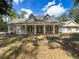 Inviting home exterior with covered porch, bright red front door, and symmetrical windows set against a partly cloudy sky at 18308 Valor Path, Brooksville, FL 34604