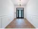 Grand foyer features stylish tile floors, white paneled walls, and a front door with glass inserts at 18308 Valor Path, Brooksville, FL 34604