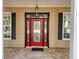 Close up of the front door, featuring a red door with glass inserts at 18308 Valor Path, Brooksville, FL 34604