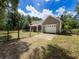 Charming single-story home with a two-car garage and metal gate in a wooded setting at 18308 Valor Path, Brooksville, FL 34604