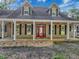 Charming home featuring a welcoming front porch with a red door, and dormer windows at 18308 Valor Path, Brooksville, FL 34604