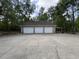Detached three-car garage featuring ample parking space and a covered carport area at 18308 Valor Path, Brooksville, FL 34604