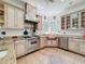 A fully-equipped kitchen with a stainless steel range hood, copper sink, and decorative tile flooring at 18308 Valor Path, Brooksville, FL 34604
