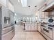Open-concept kitchen with a large refrigerator and modern appliances that opens to the dining and living spaces at 18308 Valor Path, Brooksville, FL 34604