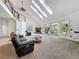 Open living room featuring a fireplace, high ceilings with skylights, and access to the backyard at 18308 Valor Path, Brooksville, FL 34604