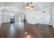 Spacious room featuring a hardwood floor, ceiling fans, and natural lighting from the windows and sliding glass door at 18308 Valor Path, Brooksville, FL 34604