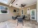 Covered patio with fire pit, comfortable seating, and ceiling fan at 18308 Valor Path, Brooksville, FL 34604