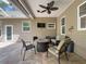 Covered patio with fire pit, comfortable seating, and ceiling fan at 18308 Valor Path, Brooksville, FL 34604