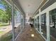 The covered back porch, accessible through French doors, overlooks a garden and has a beautiful tile floor at 18308 Valor Path, Brooksville, FL 34604
