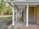 Long front porch adorned with white pillars and ceiling fans creates an inviting entryway to the home at 18308 Valor Path, Brooksville, FL 34604