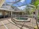 This outdoor pool has a safety fence and an outdoor garden with tropical plants on a stone patio at 18308 Valor Path, Brooksville, FL 34604
