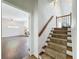 Carpeted staircase adjacent to a living space, leading upstairs with wood railing and iron balusters at 18308 Valor Path, Brooksville, FL 34604