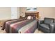A comfortable main bedroom with plush bedding, natural light, and a cozy chair at 3260 Haviland Ct # 201, Palm Harbor, FL 34684