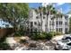 Building exterior of a townhome with mature trees and lush landscaping in the front at 3260 Haviland Ct # 201, Palm Harbor, FL 34684