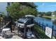 Outdoor grilling area with a stainless steel grill, seating, and picturesque water view at 3260 Haviland Ct # 201, Palm Harbor, FL 34684