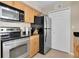 The kitchen features stainless steel appliances, tan wood cabinets, and hard surface countertops at 3260 Haviland Ct # 201, Palm Harbor, FL 34684