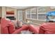 Bright living room features a fireplace, neutral paint, three picture windows, and wood-look floors at 3260 Haviland Ct # 201, Palm Harbor, FL 34684