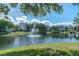 A serene pond with a fountain surrounded by lush landscaping and residential buildings at 3260 Haviland Ct # 201, Palm Harbor, FL 34684