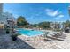 Community pool with lounge chairs, tables, plants and trees surrounding the area at 3260 Haviland Ct # 201, Palm Harbor, FL 34684