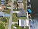 This elevated view features the house, its gray roof, wide driveway, canal access and dock for watercraft at 3362 Minnow Creek Dr, Hernando Beach, FL 34607
