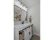 Bathroom featuring a modern vanity with a stone countertop, modern fixtures, and a dark metal-framed mirror at 3362 Minnow Creek Dr, Hernando Beach, FL 34607