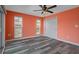 Bedroom featuring a ceiling fan, two windows, and a closet space, with bright orange walls at 3362 Minnow Creek Dr, Hernando Beach, FL 34607
