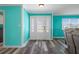 Welcoming foyer with decorative glass door, wood-look flooring, and vibrant blue-painted walls at 3362 Minnow Creek Dr, Hernando Beach, FL 34607