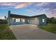 Charming waterfront home featuring a spacious driveway and attached garage under a beautiful twilight sky at 3362 Minnow Creek Dr, Hernando Beach, FL 34607