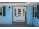 Inviting home entrance featuring a decorative glass door, sidelights, and blue wood siding at 3362 Minnow Creek Dr, Hernando Beach, FL 34607